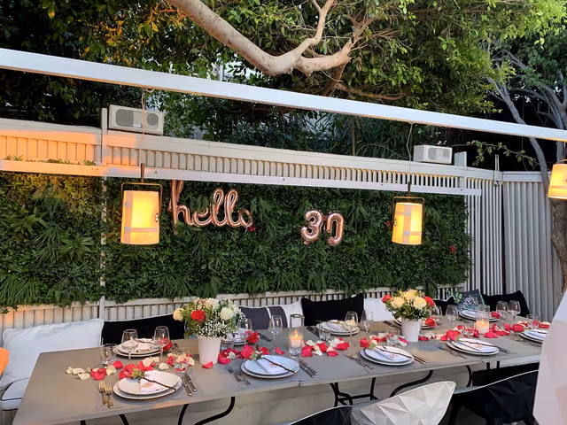 Tavolo privato di compleanno decorato con fiori e petali di rosa al Krama Mykonos