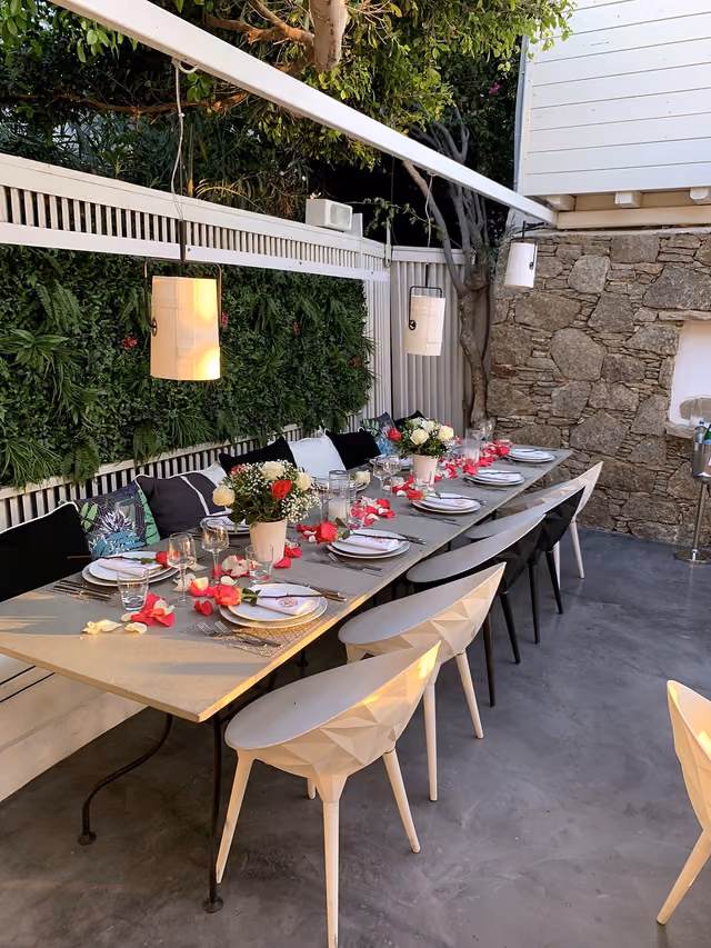 Long table prepared for a private dinner beside Krama's green wall