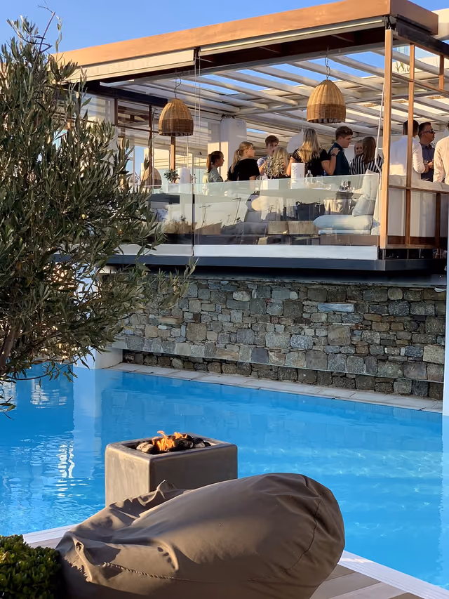 Poolside event atmosphere with guests and a glowing fire bowl at Krama